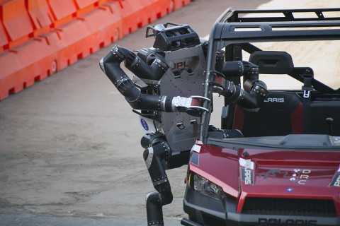 JPL's RoboSimian exits its vehicle following a brief drive through a slalom course at the DARPA Robotics Challenge Finals. (JPL-Caltech)