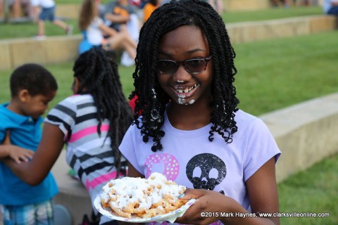 A girl enjoying her funnel cake. A girl enjoying her funnel cake.