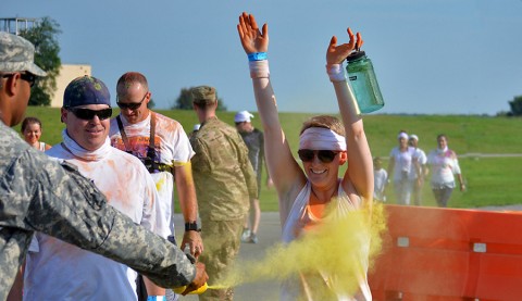 Spc. Danielle Cooper, 1st Battalion, 506th Infantry Regiment, 1st Brigade Combat Team, 101st Airborne Division (Air Assault), and her husband, Michael Cooper, are blasted with yellow-dyed corn starch at the one-mile mark of the color run here July 18, 2015. The color run took place as part of the Eagle Challenge Fitness Tour. (Staff Sgt. Sierra Fown 2nd Brigade Combat Team, 101st Airborne Division (AA) Public Affairs)