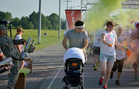 Sgt. Brittany M. Bambary, Headquarters and Headquarters Battalion, Division Artillery, 101st Airborne Division (Air Assault), her husband, Patrick Bambery, and their 5-month-old daughter are blasted with color at the start of the run here July 18, 2015. The color run took place as part of the Eagle Challenge Fitness Tour. (Staff Sgt. Sierra A. Fown, 2nd Brigade Combat Team, 101st Airborne Division (Air Assault) Public Affairs)