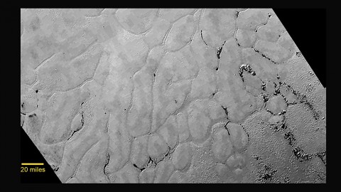 In the center left of Pluto’s vast heart-shaped feature – informally named “Tombaugh Regio” - lies a vast, craterless plain that appears to be no more than 100 million years old, and is possibly still being shaped by geologic processes. This frozen region is north of Pluto’s icy mountains and has been informally named Sputnik Planum (Sputnik Plain), after Earth’s first artificial satellite. The surface appears to be divided into irregularly-shaped segments that are ringed by narrow troughs. (NASA/JHUAPL/SWRI)