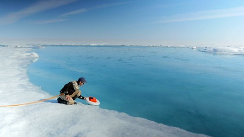 Laurence Smith (University of California, Los Angeles) deploys an autonomous drift boat equipped with several sensors in a meltwater river on the Greenland ice sheet. (NASA's Goddard Space Flight Center/Jefferson Beck)