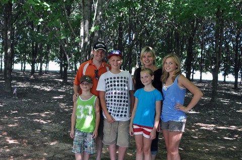 Janice Nikkel stands at the Gander Memorial Site at Fort Campbell, Ky., with her husband and children 25 years after the trees she donated were planted in 2010. When Nikkel was 15, she donated $20 in order to have one tree planted for every life lost during the Gander crash. (Courtesy photo)