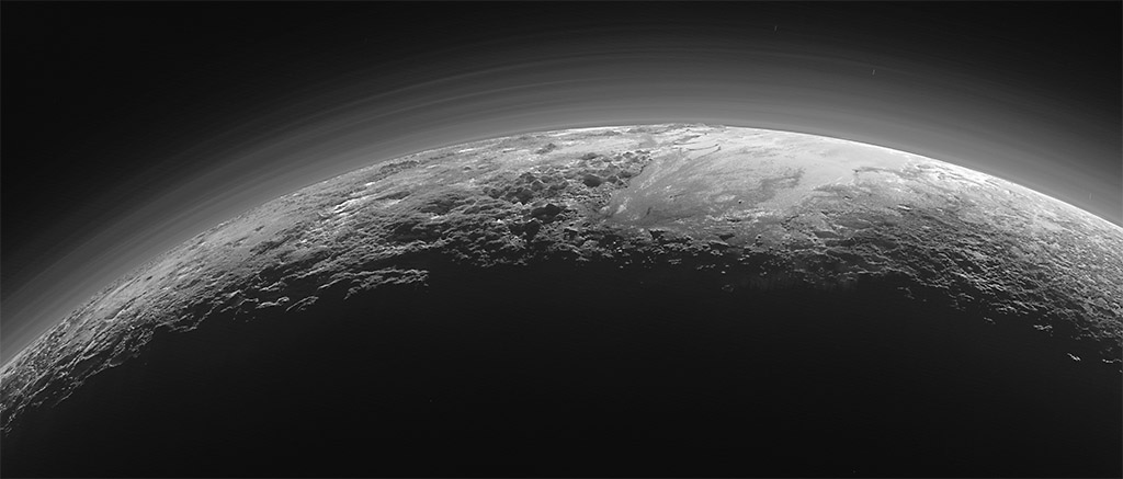 Pluto’s Majestic Mountains, Frozen Plains and Foggy Hazes: Just 15 minutes after its closest approach to Pluto on July 14, 2015, NASA’s New Horizons spacecraft looked back toward the sun and captured this near-sunset view of the rugged, icy mountains and flat ice plains extending to Pluto’s horizon. (NASA/JHUAPL/SwRI)