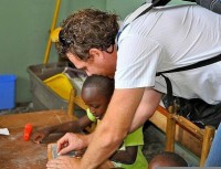 Simon Lawrence, working with child in Uganda.