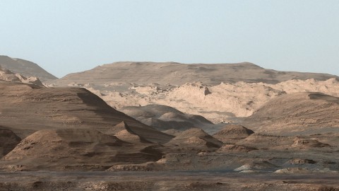 This composite image looking toward the higher regions of Mount Sharp was taken on September 9, 2015, by NASA's Curiosity rover. In the foreground -- about 2 miles (3 kilometers) from the rover -- is a long ridge teeming with hematite, an iron oxide. (NASA/JPL-Caltech/MSSS)