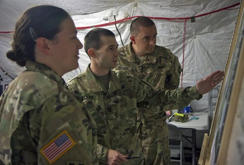 Maj. Mindi Furnier, a military intelligence officer, Capt. David-Shea Melloy, an operations planner, and Warrant Officer Mike Rieber, an imagery technician with the 101st Airborne Division (Air Assault), coordinate plans for split-based operations during Warfighter Exercise 16-02 at Fort Campbell, Ky., Nov. 19. The WFX tested the 101st staff sections' abilities to coordinate with other combat and combat support elements in a simulated full-scale war. (Sgt. William White, 101st Airborne Division Public Affairs)