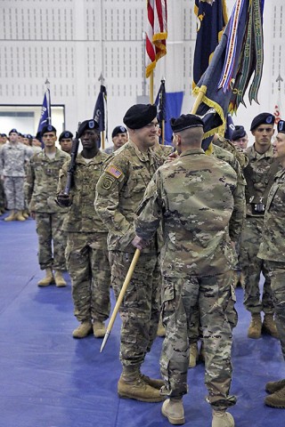 Lt. Col. David Waters, commander of 1st Battalion, 506th Infantry Regiment, 1st Brigade Combat Team, 101st Airborne Division (Air Assault), passes the guidon to Command Sgt. Maj. James Brasher, the incoming “Red Currahee” command sergeant major, during the change of responsibility ceremony Dec. 1, 2015 at Sabo Gym. Passing the guidon from the outgoing command sergeant major to the incoming is a tradition that signifies the transfer of responsibility within the battalion. (Sgt. Samantha Stoffregen, 1st Brigade Combat Team, 101st Airborne Division (Air Assault) Public Affairs)