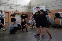 Sgt. 1st Class Liela Cowhig, a senior instructor for the Master Fitness Training Course, demonstrates how to position a Soldier before lifting him during an MFTC at Fort Campbell, Ky., Jan. 26, 2016. Cowhig and the other MFTC instructors spent two weeks at Fort Campbell teaching 101st Airborne Division (Air Assault) Soldiers about nutrition and exercise science. (Sgt. William White, 101st Airborne Division Public Affairs)