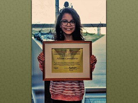 Allison Candalario, a fourth grader from Barsanti Elementary School, receives a certificate of appreciation for her outstanding volunteer service at the 101st Airborne Division headquarters building, Fort Campbell, Ky., Feb. 19, 2016. Candalario assisted in family readiness group events in which she helped bake goods to raise money and decorate for unit functions. (U.S. Army Sgt. Neysa Canfield, 101st Sustainment Brigade Public Affairs)