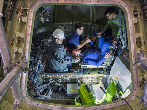 Engineers at NASA’s Langley Research Center in Hampton, Virginia, install test dummies into the crew suits of an Orion test article. The capsule, coupled with the heat shield from the spacecraft’s first flight, will be used for water-impact testing to simulate what astronauts would experience when landing in the Pacific Ocean during a real mission. (NASA/David C. Bowman)