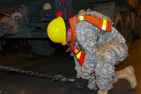 A Soldier from 372nd Inland Cargo Transfer Company, 129th Combat Sustainment Support Battalion, 101st Sustainment Brigade, 101st Airborne Division (Air Assault), breaks a chain in release the vehicle and effectively unload it from USNS Benavidez at Port Arthur, Tx., April 26, 2016. (Sgt. Neysa Canfield, 101st Sustainment Brigade Public Affairs)