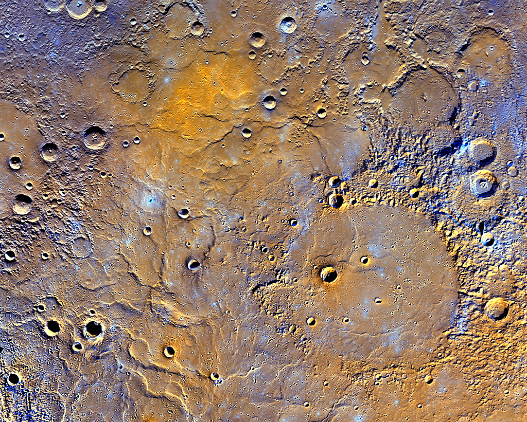 A view of Mercury’s northern volcanic plains is shown in enhanced color to emphasize different types of rocks on Mercury’s surface. In the bottom right portion of the image, the 181-mile- (291-kilometer)-diameter Mendelssohn impact basin, named after the German composer, appears to have been once nearly filled with lava. Toward the bottom left portion of the image, large wrinkle ridges, formed during lava cooling, are visible. (NASA/JHUAPL/Carnegie Institution of Washington)