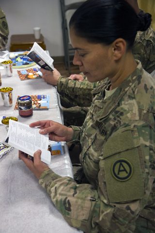 Sgt. Xochi Risco, a chaplain’s assistant from 42nd Regional Support Group, follows along in a prayer book during a Seder meal at the Baghdad Diplomatic Support Center in Baghdad April 30, 2016. Risco, a member of the New Jersey National Guard, volunteered for the Passover mission as a chaplain’s assistant even though she isn’t Jewish. (U.S. Army photo by Sgt. Katie Eggers)