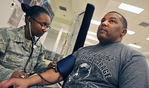 U.S. Air Force Staff Sgt. Alecia Peel-Thompson, 18th Medical Operations Squadron aerospace medical technician, checks the blood pressure of a patient. The Joint Outpatient Experience Survey will combine patient surveys used by the services to learn about beneficiary health care experiences with the goal of making them better. (U.S. Air Force Naoto Anazawa)