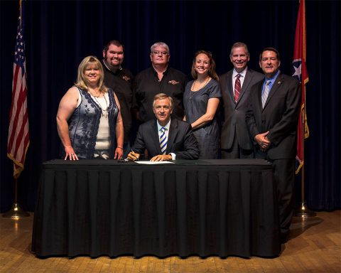 (L to R) Mother, Margaret Davis, son, (John) J.T. Davis, father, Brian Davis, Carrie Russell, State Representative Joe Pitts and Senator Mark Green. Pictured in front  Governor Bill Haslam.