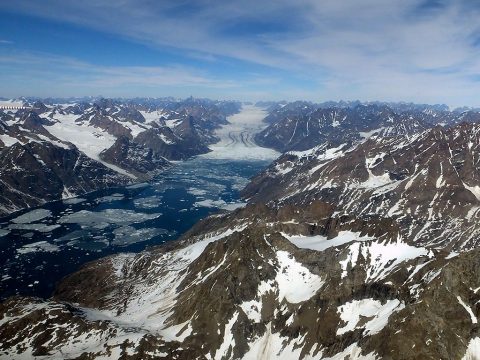 Glacier de France emptying into the Denmark Strait, Greenland. An ice melange, or a mix of broken icebergs and sea ice, is visible at front of the glacier. Photo taken during NASA's Operation IceBridge Helheim-Kangerdlugssuap Gap B mission on May 17, 2016. (NASA/Maria-José Viñas)