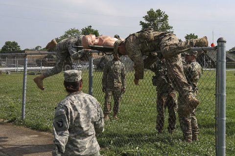 Medics with 1st Brigade Combat Team, 101st Airborne Division (Air Assault) crawl over a fence while transporting a simulated casualty on Johnson field during the brigade’s Expert Field Medical Badge train-up May 26, 2016. The Soldiers must be able to complete more than 200 tasks if they want to earn the EFMB at the end of June. (Sgt. Samantha Stoffregen, 1st Brigade Combat Team, 101st Airborne Division (Air Assault) Public Affairs)