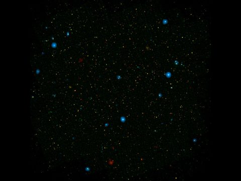 The blue dots in this field of galaxies, known as the COSMOS field, show galaxies that contain supermassive black holes emitting high-energy X-rays. (NASA/JPL-Caltech)