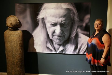 Jerry Church standing next to the portrait of Olen Bryant and one of his sculptures at the Customs House Museum.