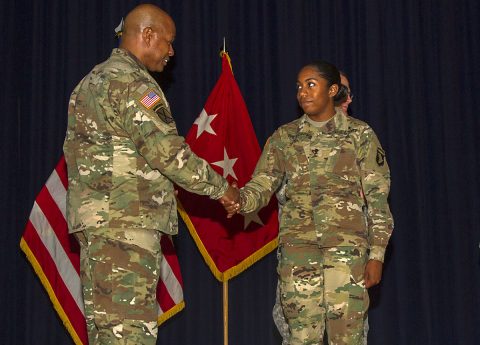 Lt. Gen. Larry D. Wyche, deputy commanding general for the United States Army Material Command, presents Spc. Iverem Wilson, a nodal network systems operator – maintainer with 58th Signal Company, 101st Special Troops Battalion, 101st Airborne Division Sustainment Brigade, 101st Abn. Div. (Air Assault), with a coin at Wilson Theater on Fort Campbell, Ky., Aug. 9, 2016, for her outstanding performance as Distinguished Honor Graduate from the Basic Leaders Course. (Sgt. Neysa Canfield, 101st Airborne Division Sustainment Brigade Public Affairs) 