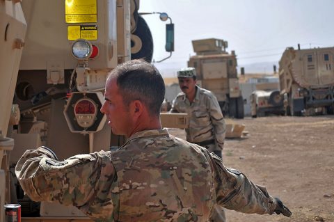 Staff Sgt. Vincent Boyd, left, a trainer with Headquarters and Headquarters Company, 2nd Battalion, 502nd Infantry Regiment, Task Force Strike, demonstrates to a Peshmerga soldier how to signal to properly hook a tow winch to another vehicle during vehicle recovery training, in Erbil, Iraq, June 22, 2016. U.S. and German personnel tested Peshmerga soldiers on proper vehicle recovery techniques during the training. (1st Lt. Daniel Johnson/Released) 