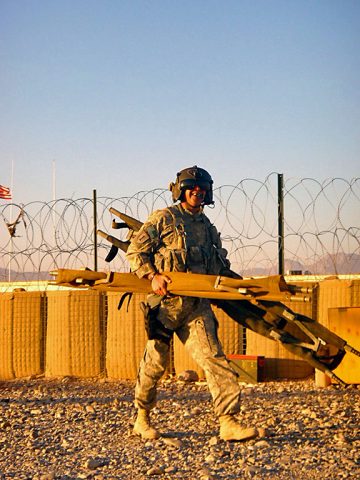 "During a deployment, Sgt. 1st Robert Class Minor carries litters to an aircraft in order to prepare a Blackhawk for follow on medical evacuation missions." (6th Battalion, 101st Aviation Brigade)