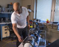Electrical engineer Larry Greer sets up a homemade wind tunnel to test a saltation probe. (NASA)
