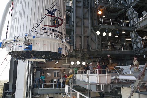 The OSIRIS-REx spacecraft, enclosed in a payload fairing, is lifted Aug. 29 at Space Launch Complex 41 at Cape Canaveral Air Force Station in Florida. The United Launch Alliance Atlas V rocket that is to lift OSIRIS-REx into space was stacked at SLC-41 so the spacecraft and fairing could be hoisted up and bolted to the rocket. (NASA/Dimitri Gerondidakis)