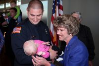 Clarksville Mayor Kim McMillan smiles at Lexie Huff, infant daughter of newly sworn Clarksville Firefighter Matt Huff. Lexie was born on Huff’s third day at the fire academy earlier this year. Huff was among 19 new firefighters who took the Clarksville Fire Rescue service oath Friday.