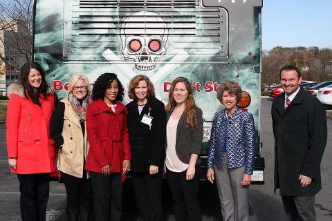 Members of the MCHD Health Education Team join Mayor Kim McMillan and MCHD Director Joey Smith in front of bus graphics that proclaim “Be Smart, Don’t Start.” Creatively, the eyes of the skeleton light up when the bus brakes are engaged.