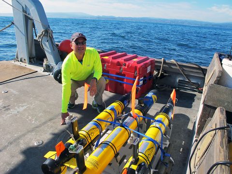 JPL's Steve Chien with several of the underwater drones used in a research project earlier this year. Chien, along with his research collaborators, are developing artificial intelligence for these drones. (NASA/JPL-Caltech)