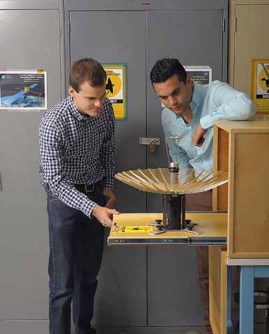 RainCube's radiofrequency lead Nacer Chahat (right) and mechanical engineer lead Jonathan Sauder (left) observe the CubeSat's deployed antenna. (NASA/JPL-Caltech)