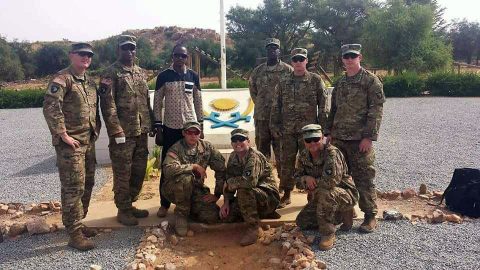 The team from 2nd Battalion, 327th Infantry Regiment, of the 1st Brigade Combat Team "Bastogne", 101st Airborne Division (Air Assault), poses in front of the Nigerien Armed Forces basic training crest. Standing from left to right: Sgt. 1st Class Michael Mullins, Staff Sgt. Cameron Marsh, Interpreter Mr. Abdourahmane Ibrahim, Sgt. 1st Class Elocious Frazier, Sgt. 1st Class Sean Carey, 1st Lt. Dan Godlasky. Kneeling from left to right: Staff Sgt. Matthew England, Staff Sgt. Andrew Prince, First Sgt. Peter Russell. (Moussa Moumouni) The team from 2nd Battalion, 327th Infantry Regiment, of the 1st Brigade Combat Team "Bastogne", 101st Airborne Division (Air Assault), poses in front of the Nigerien Armed Forces basic training crest. Standing from left to right: Sgt. 1st Class Michael Mullins, Staff Sgt. Cameron Marsh, Interpreter Mr. Abdourahmane Ibrahim, Sgt. 1st Class Elocious Frazier, Sgt. 1st Class Sean Carey, 1st Lt. Dan Godlasky. Kneeling from left to right: Staff Sgt. Matthew England, Staff Sgt. Andrew Prince, First Sgt. Peter Russell. (Moussa Moumouni)