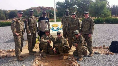 The team from 2nd Battalion, 327th Infantry Regiment, of the 1st Brigade Combat Team "Bastogne", 101st Airborne Division (Air Assault), poses in front of the Nigerien Armed Forces basic training crest. Standing from left to right: Sgt. 1st Class Michael Mullins, Staff Sgt. Cameron Marsh, Interpreter Mr. Abdourahmane Ibrahim, Sgt. 1st Class Elocious Frazier, Sgt. 1st Class Sean Carey, 1st Lt. Dan Godlasky. Kneeling from left to right: Staff Sgt. Matthew England, Staff Sgt. Andrew Prince, First Sgt. Peter Russell. (Moussa Moumouni)