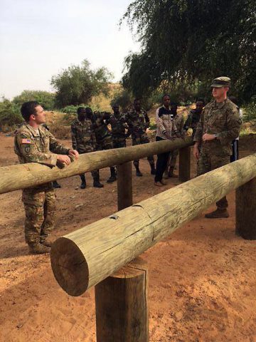 Sgt. 1st Class Michael Mullins instructs the officers of Nigerien Armed Forces (FAN) basic training school on how to properly conduct the “Six Vaults” obstacle, while Staff Sgt. Andrew Prince prepares to demonstrate. (1st Lt. Daniel Godlasky)