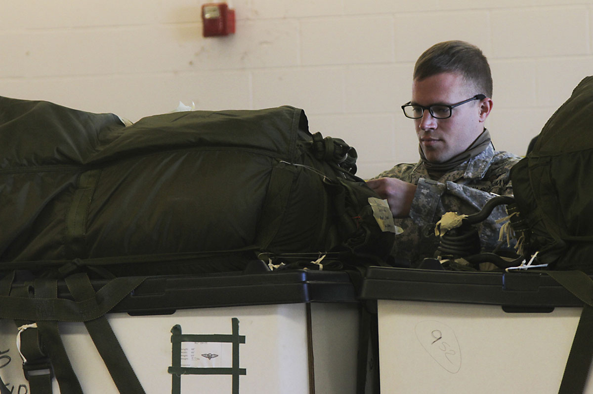 A parachute rigger with 861st Quartermaster Company, a reserve unit from Nashville, TN, inspects a bundle before loading it on an aircraft, Dec. 7, 2016, at the airfield on Fort Campbell, KY. Soldiers from 861st QM Co. unite with Soldiers from 74th Transportation Co., to conduct aerial delivery and recovery training in order to refresh their skills. (U.S. Army photo by Sgt. Neysa Canfield/101st Airborne Division Sustainment Brigade Public Affairs)