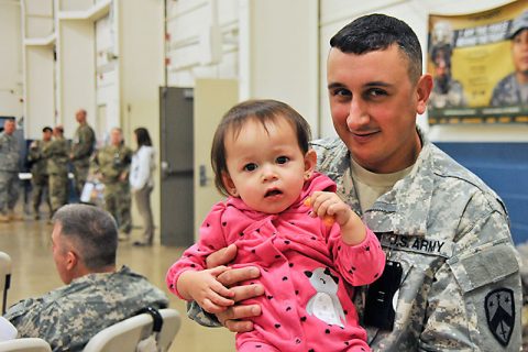 Staff Sgt. Aaron Canfield, of Nashville, says good-bye to his daughter during the farewell ceremony for the 230th Signal Company at Houston Barracks on December 4, prior to embarking on a one-year deployment to the Middle East. (Sgt. 1st Class Edgar Castro)