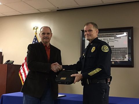 Sergeant Marty Watson recieves his duty weapon from Clarksville Police Chief Al Ansley during Watson's retirement celebration.