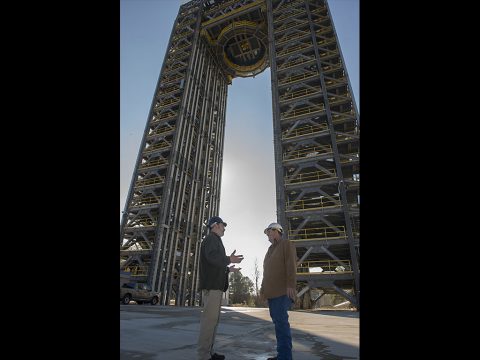 Robert Bobo, left, and Mike Nichols talk beneath the 221-foot-tall Test Stand 4693, the largest of two new Space Launch System test stands at NASA's Marshall Space Flight Center in Huntsville, Alabama. Bobo manages SLS structural strength testing, and Nichols is lead test engineer for the SLS liquid hydrogen tank, which the stand will subject to the forces it must endure during launch and flight. (NASA/MSFC/Emmett Given)