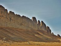 This photograph from Shiprock in northwestern New Mexico shows a ridge roughly 30 feet (about 10 meters) tall that formed from lava filling an underground fracture then resisting erosion better than the material around it did. (NASA/JPL-Caltech)