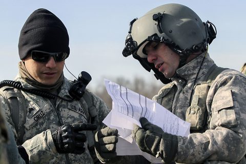 Sgt. Timothy Cruz, left, noncommissioned officer in charge of a sling load training operation for 58th Signal Company, 101st Special Troops Battalion, 101st Airborne Division (Air Assault) Sustainment Brigade, 101st Abn. Div., goes over paperwork with a CH-47 Chinook helicopter pilot from 101st Combat Aviation Brigade, 101st Abn. Div., before the company’s sling load operation Feb. 10, 2017, on Fort Campbell, Kentucky. (Sgt. Neysa Canfield/101st Airborne Division Sustainment Brigade Public Affairs) 