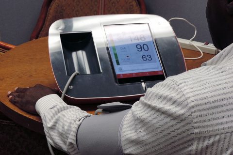 Man checking blood pressure at office kiosk. (American Heart Association)