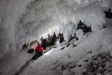 Aaron Curtis, a postdoctoral scholar at JPL, surveys frost growing in an ice cave under Mt. Erebus, an active volcano in Antarctica. (Dylan Taylor)