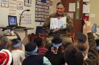 Pfc. Elise M. Fuentes, a military police with 218th Military Police Company, 716th MP Battalion, 101st Airborne Division (Air Assault) Sustainment Brigade, 101st Abn. Div., shows first grade students the illustrations in a book, March 2, 2017, during Read Across America Day at Marshall Elementary School on Fort Campbell, Kentucky. (Sgt. Neysa Canfield/101st Airborne Division Sustainment Brigade Public Affairs)