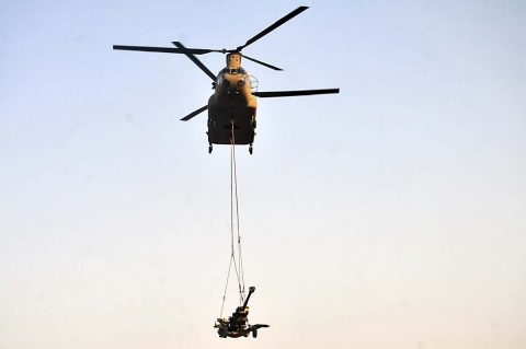 A CH-47 Chinook helicopter piloted by U.S. Army aviators with the 224th Aviation Regiment, 29th Infantry Division, lifts off with an M777 howitzer from Battery C, 1st Battalion, 320th Field Artillery Regiment, Task Force Strike, during a sling load training exercise Aug. 12, 2016, in Erbil, Iraq. (1st Lt. Daniel Johnson)