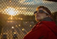 A boy wearing protective viewing glasses watches a partial solar eclipse from Arlington, Virginia, in 2014. (NASA/Bill Ingalls)