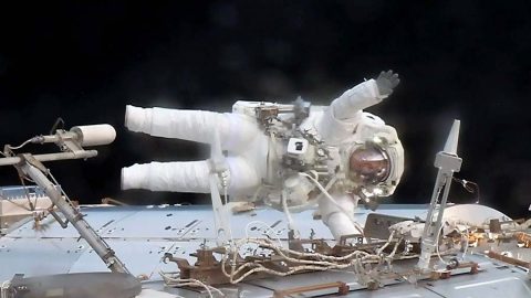 Astronaut Jack Fischer waves while attached to the Destiny laboratory during a spacewalk to replace a failed data relay box and install a pair wireless antennas. (NASA)