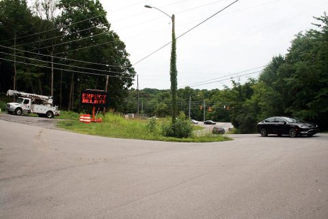 This view east of the intersection of Warfield Boulevard and Dunbar Cave Road shows the early signs of road construction to come: A truck ready for utility relocation work, a warning sign and the busy intersection.