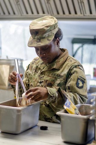 Specialist Destinee Slaton, a food service specialist assigned to E Company, 6th Battalion, 101st General Support Aviation Battalion, 101st Combat Aviation Brigade, 101st Airborne Division, prepares lunch for the field feeding portion of the Philip A. Connelly Program Aug. 9 at Fort Campbell, Kentucky. Slaton and her team are representing the XVIII Airborne Corps in the U.S. Army Forces Command level portion of the competition. (Leejay Lockhart, Fort Campbell Public Affairs Office)